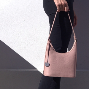 Model holding the Carlotta small Italian leather shoulder bag by the strap