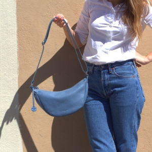 Close-up of mini leather crossbody bag in fairy color, highlighting soft calf pebbled leather and adjustable strap