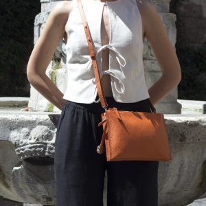 Italian leather crossbody bag Linda in orange color worn by a model