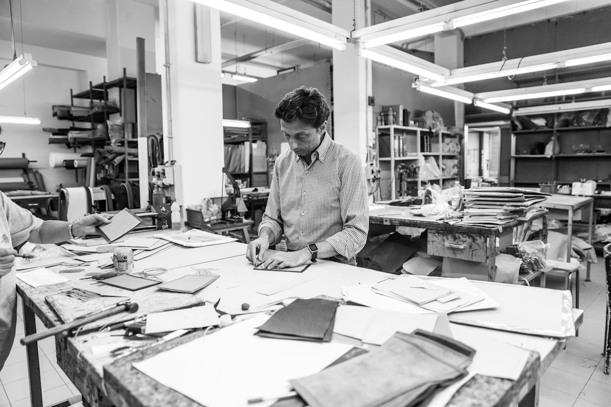 Artigiano mentre realizza una borsa fatta a mano, nel laboratorio di pelletteria a Roma di Del Giudice